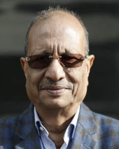 Conceptual image of corporate investigation in Nepal, featuring a silhouetted businessman in a suit against a backdrop of financial charts and a subtle steel factory structure.